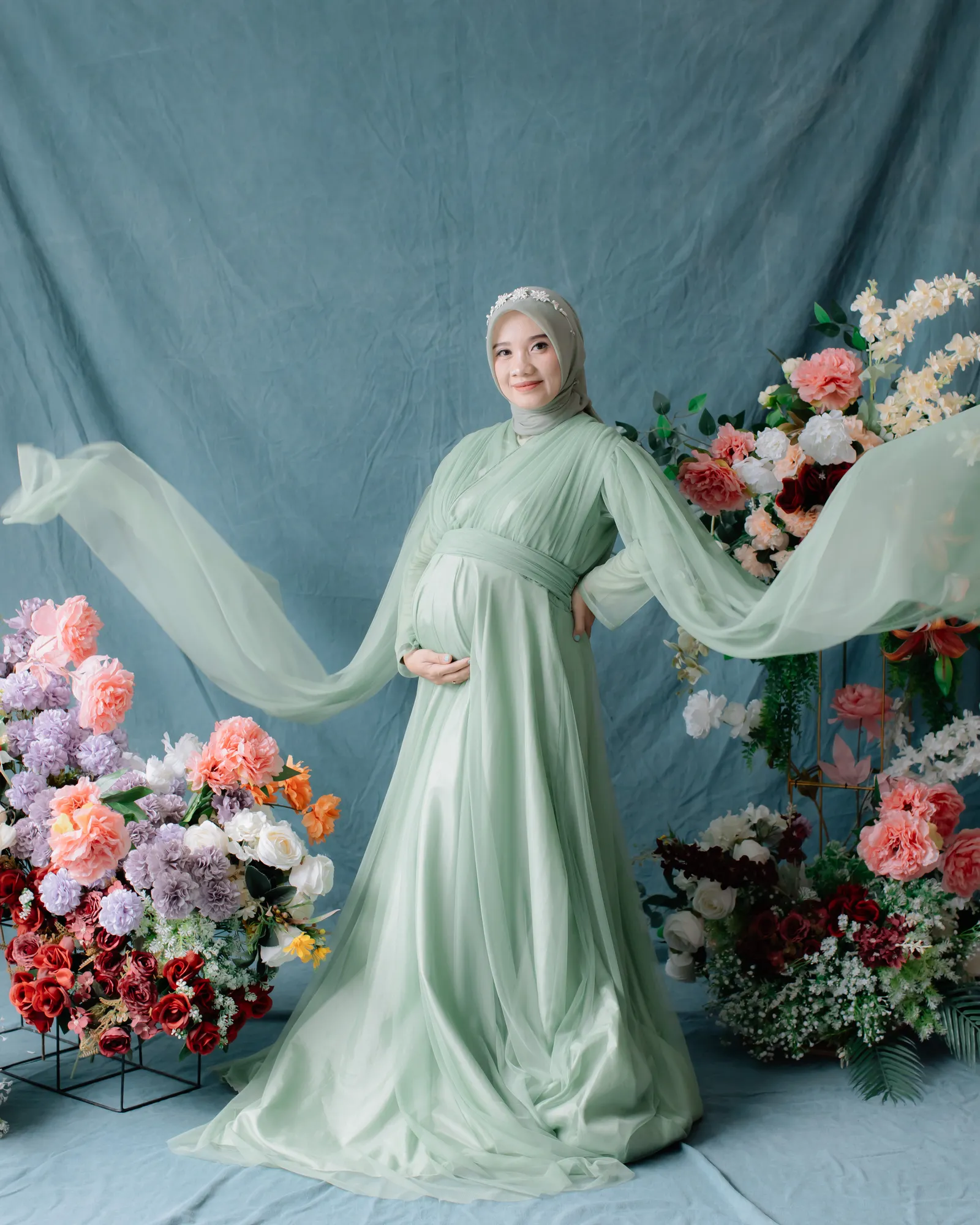 Ibu hamil berpose lembut dengan gaun maternity